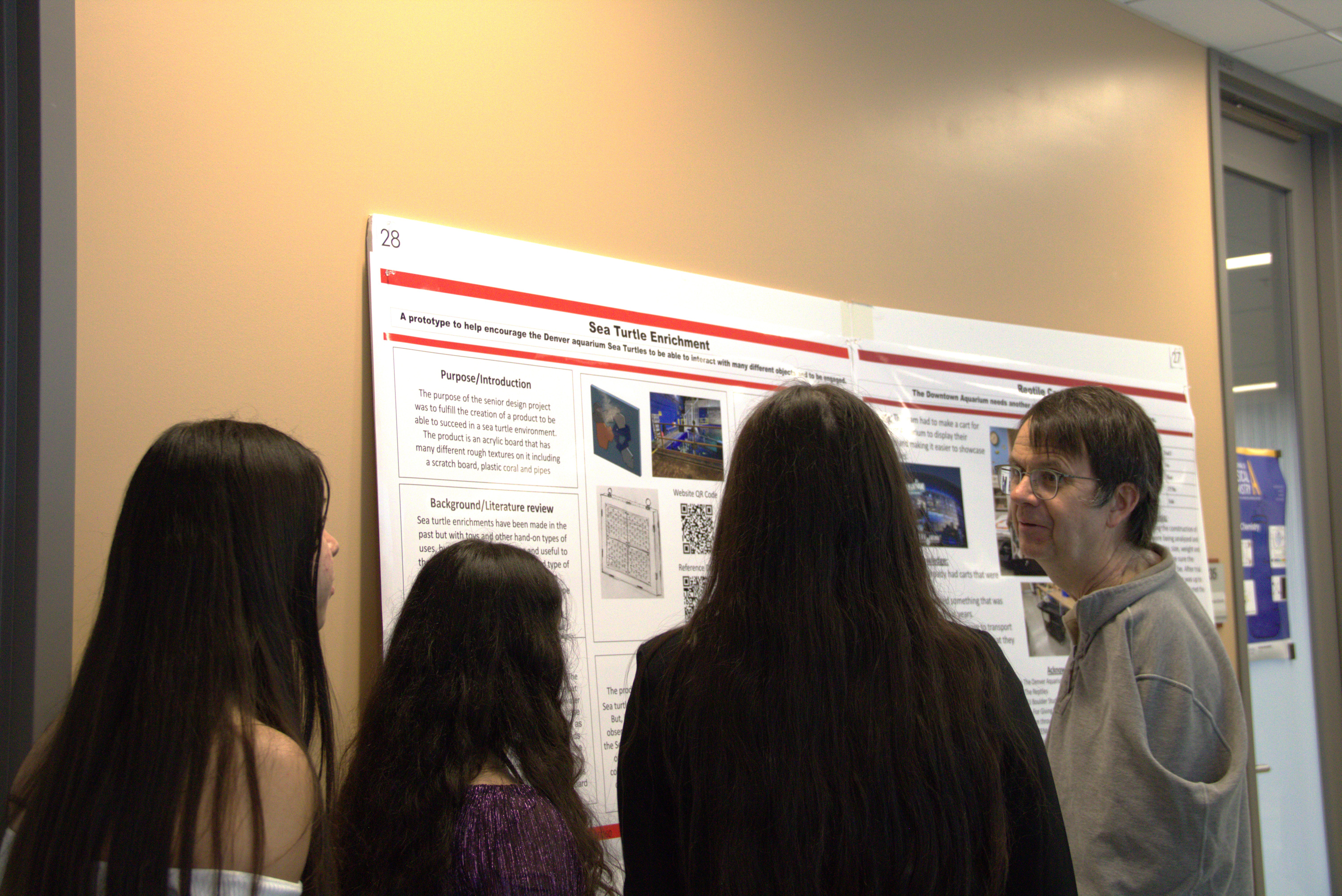 JILA and NIST Fellow Eric Cornell listens as high school students explain their project
