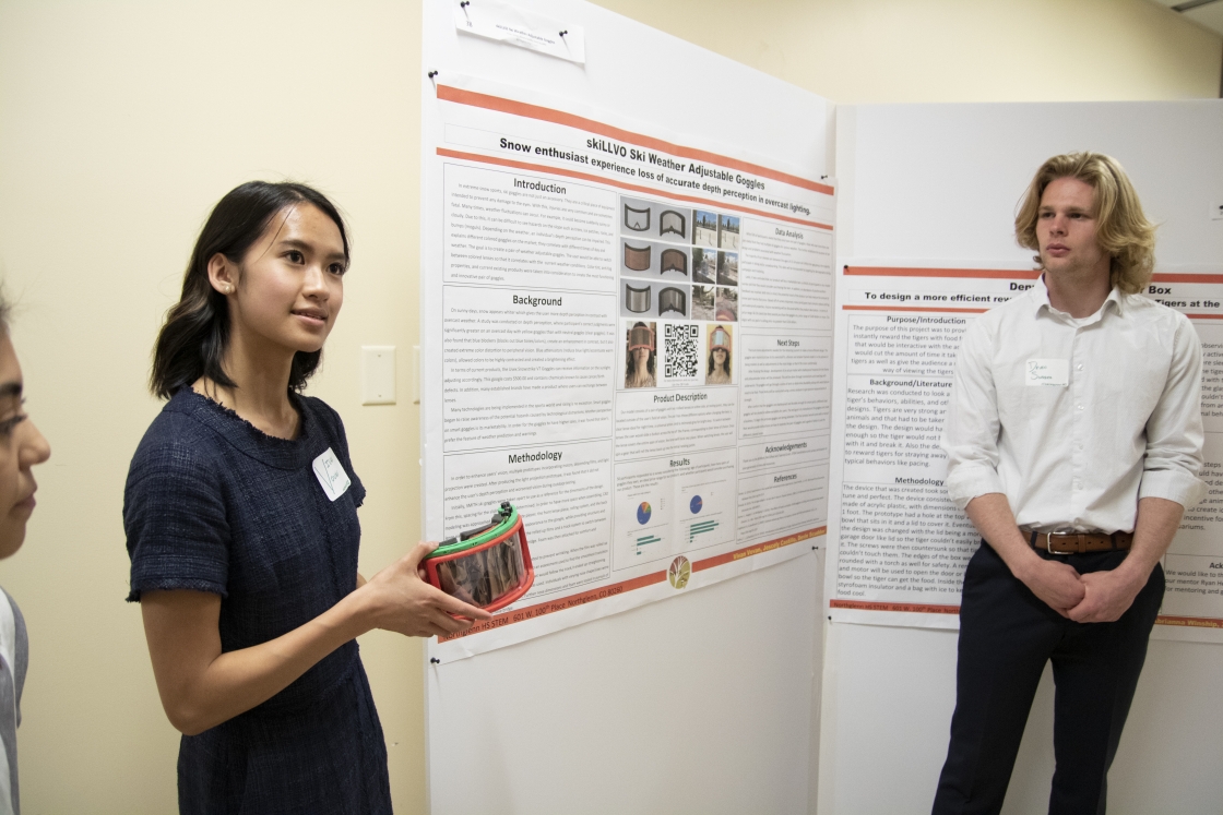 Vivan Vovan from Northglenn High School presents their skiLLVO Ski Weather Adjustable Goggles at the PISEC High School Poster Symposium.