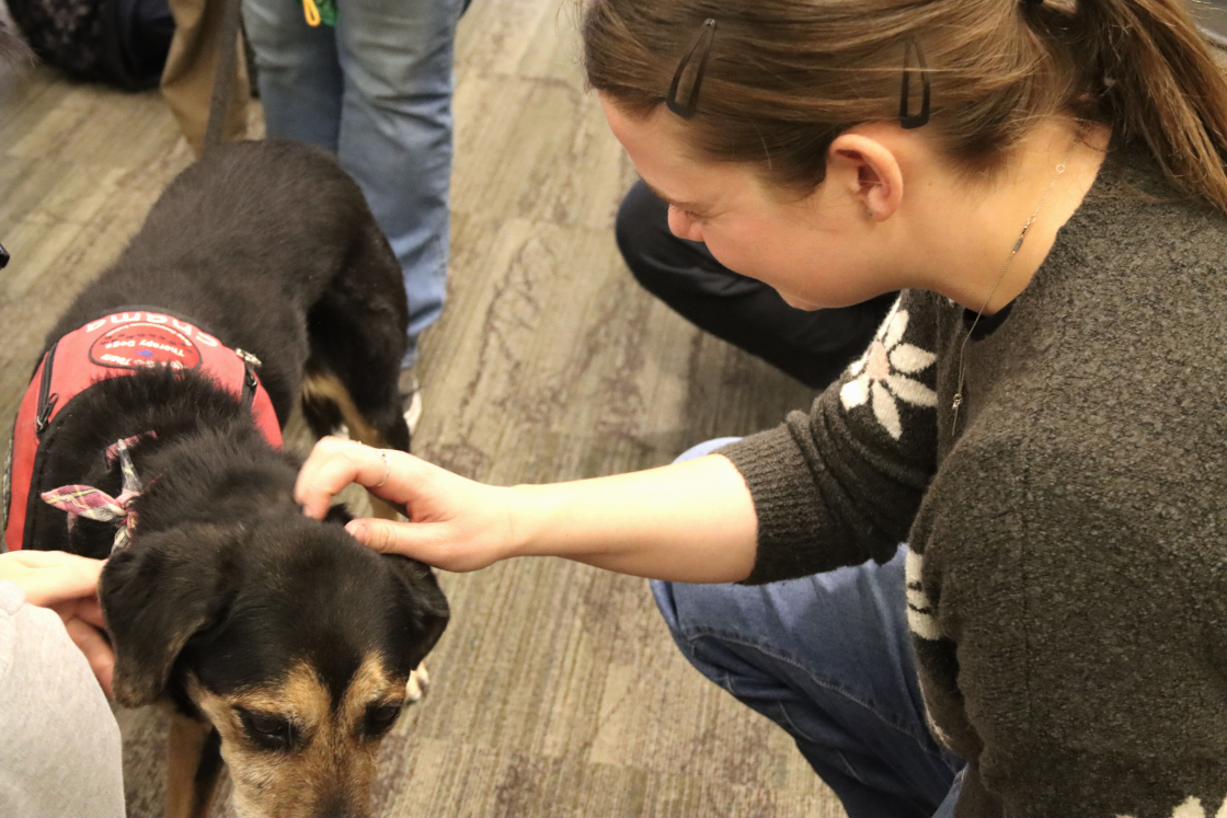 JAGS co-leader Emma Nelson pets Charma during the recent therapy dog visit to JILA