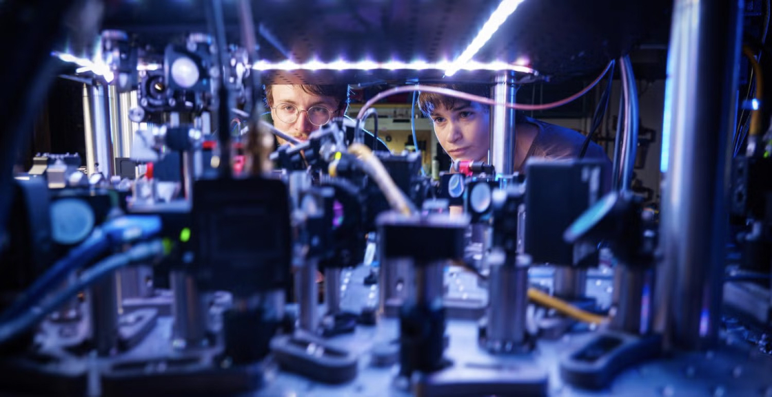 Kendall Mehling, left, and Catie LeDesma, right, with a new kind of atom "interferometer" on the CU Boulder campus. 