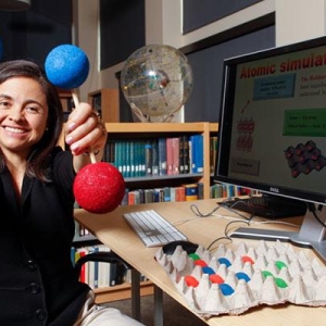 Ana Maria Rey holding up models of atoms.