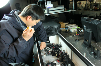 Photo of Mingming Feng adjusting a laser.