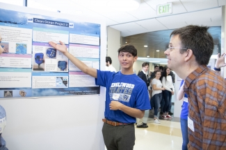 Dylan Carpenter, a student at Englewood High School, presents his group’s ocean clean up project to Dr. Eric Cornell.