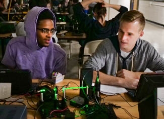 Two students working with a fiber optics setup.