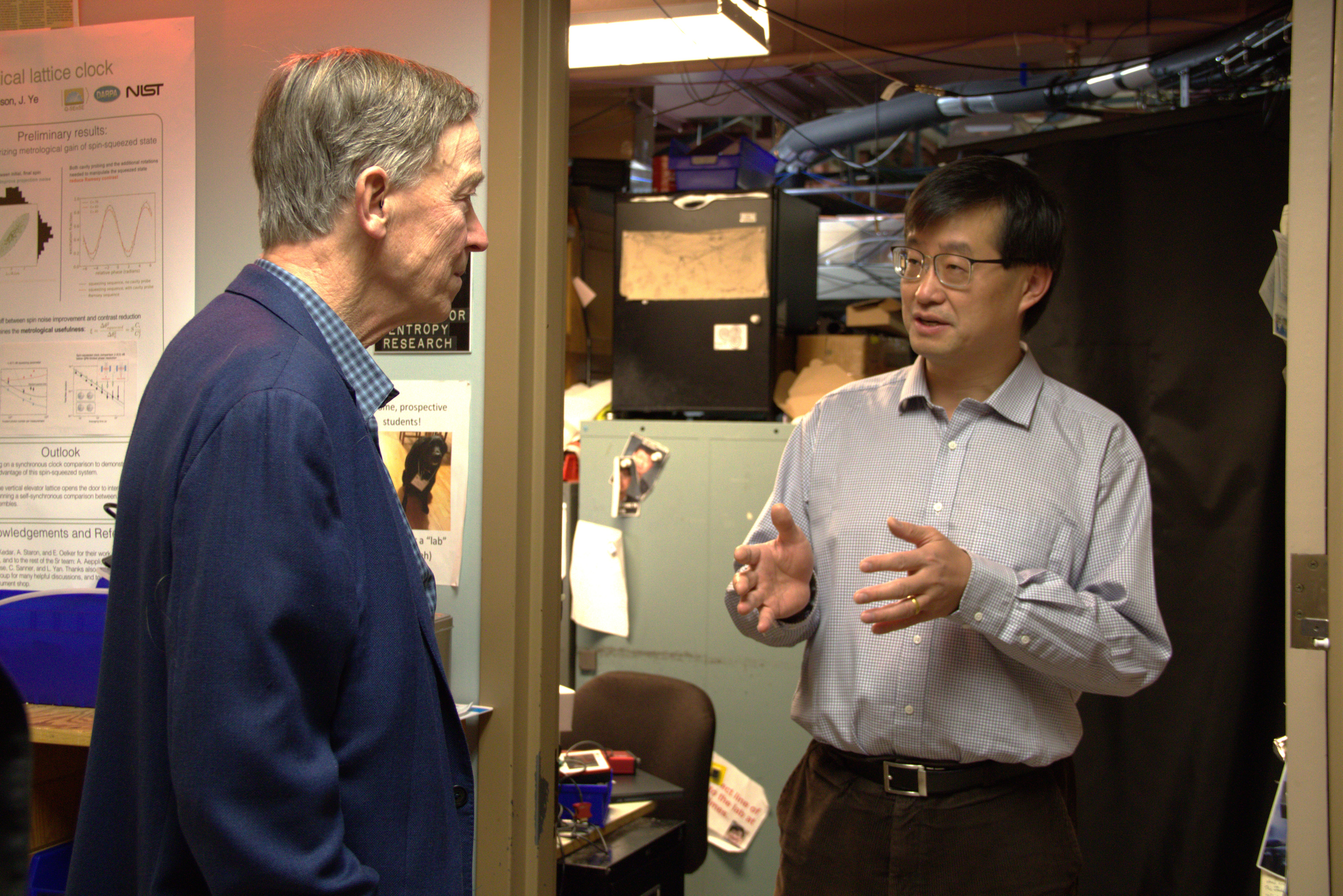 Senator Hickenlooper (left) speaks to JILA and NIST Fellow Jun Ye (right) about quantum physics