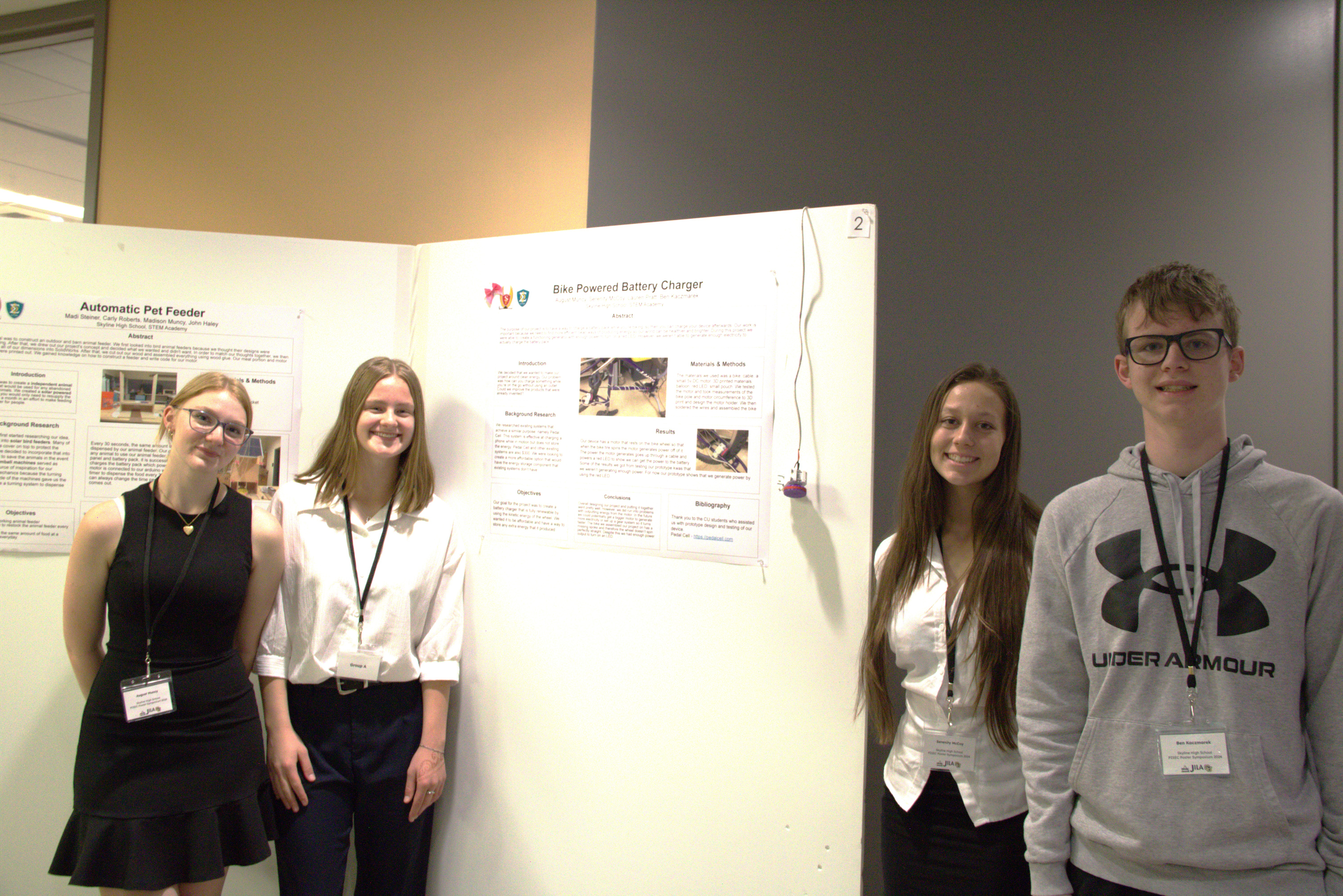 High school students proudly display the poster of their project focusing on charging batteries based on biking
