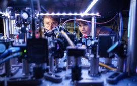 Kendall Mehling, left, and Catie LeDesma, right, with a new kind of atom "interferometer" on the CU Boulder campus. 
